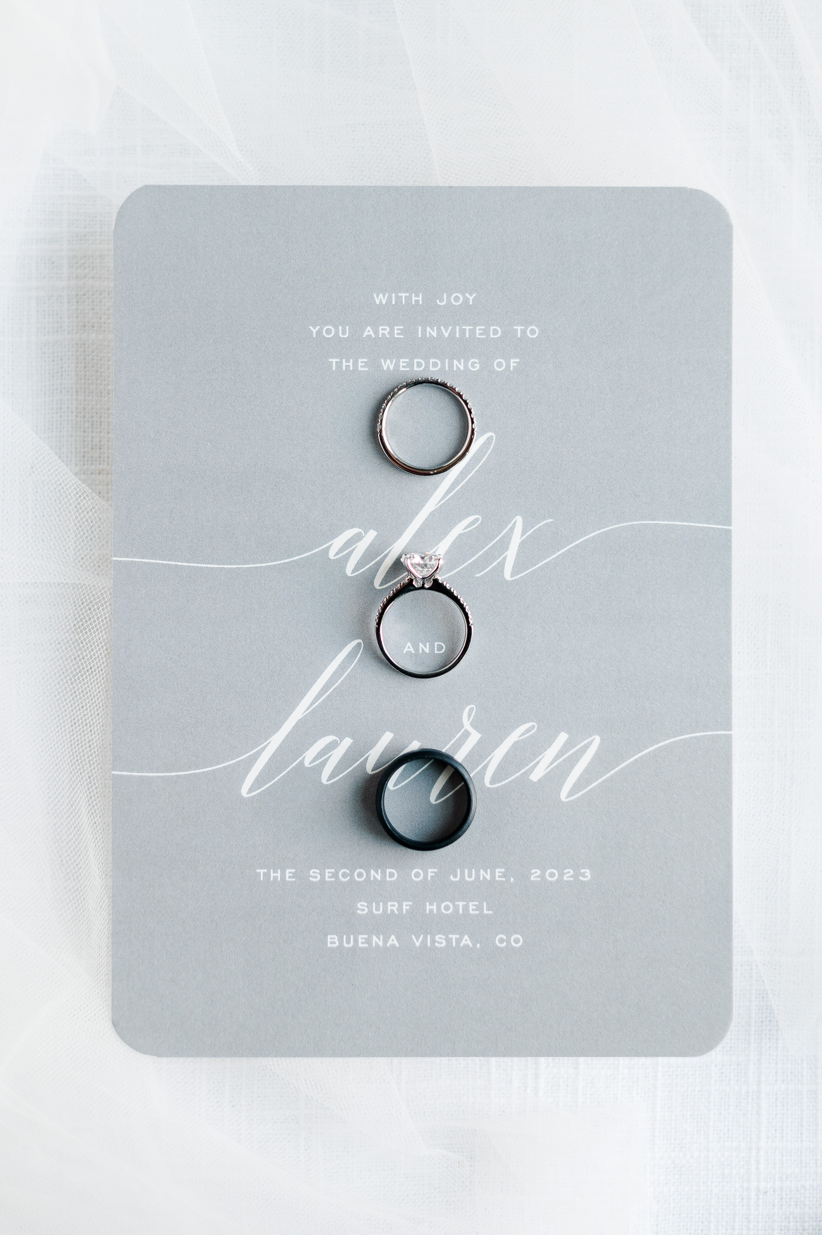 Close up photo of three wedding rings laying on a wedding invitation.
