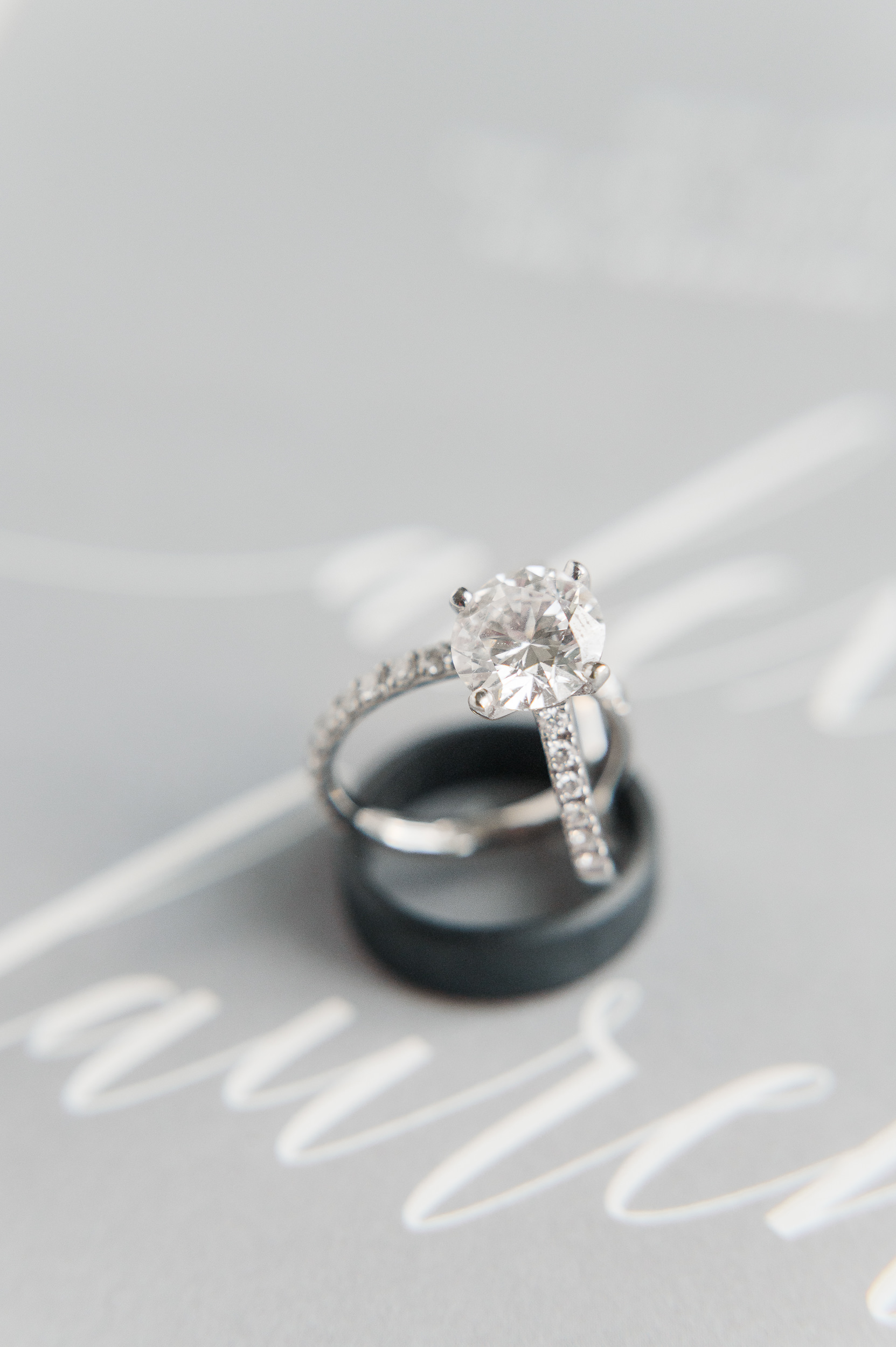Close up photo of a diamond ring sitting on a wedding band.