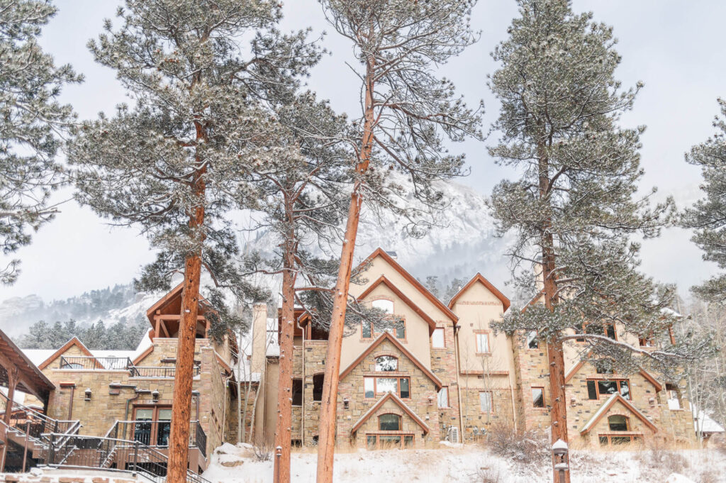 Wide shot of the outside of the Della Terra Chateau in Estes Park during the winter with snow on the ground.