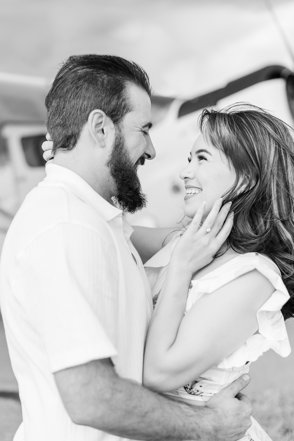 Black and white image of a man and woman smiling at each other.